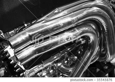 Bent exhaust pipes block. Shiny motor parts Bent exhaust pipes block. Shiny motor parts 35543876