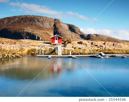 Red boat house at pier, rocky island, Norway 35544596