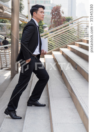 confident businessman stepping up to success confident businessman stepping up to success 35545380