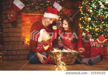 happy family mother father and baby at christmas tree at home happy family mother father and baby at christmas tree at home 35550183