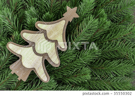 Wooden tree ornament on fir tree branches Wooden tree ornament on fir tree branches 35550302