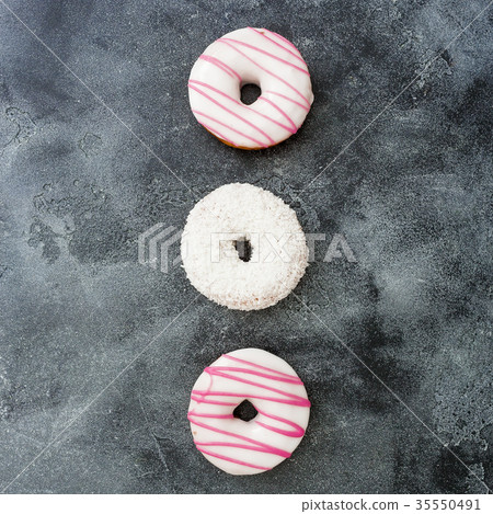 Minimal pattern of pink donuts on dark background Minimal pattern of pink donuts on dark background 35550491
