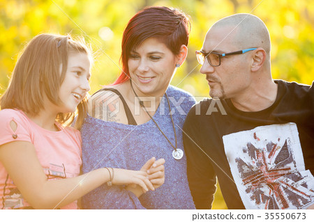 圖庫照片: mother, father and daughter lying on the grass in