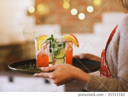 Young pretty woman with cocktails on tray 35551582