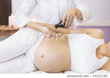 Young pregnant woman have massage treatment at spa 35552140