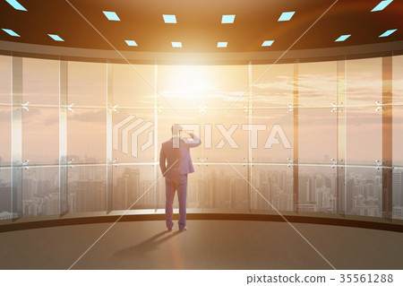 Businessman in front of office window thinking of 35561288