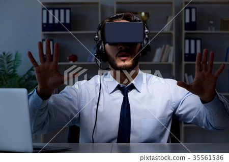 Businessman gamer staying late to play games Businessman gamer staying late to play games 35561586