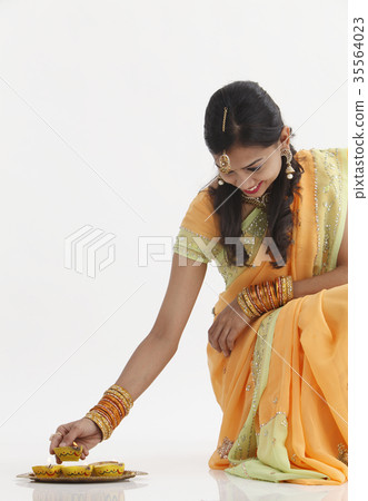 Indian woman in traditional clothing celebrating deepavali 35564023