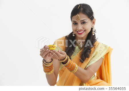 Indian woman in traditional clothing celebrating deepavali Indian woman in traditional clothing celebrating deepavali 35564035