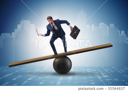 Businessman trying to balance on ball and seesaw 35564837