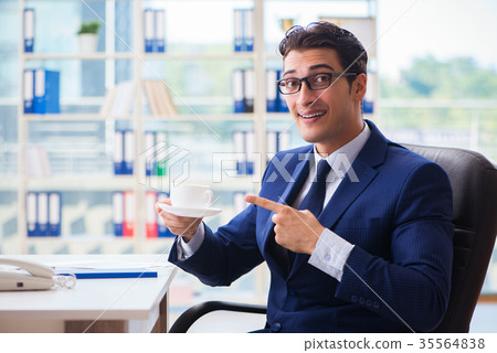 Businessman drinking coffee in the office during Businessman drinking coffee in the office during 35564838