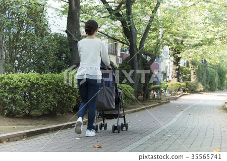 Middle woman pushing a stroller Middle woman pushing a stroller 35565741