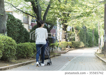 Middle woman pushing a stroller Middle woman pushing a stroller 35565742