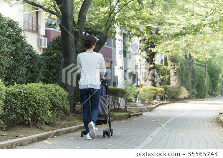 Middle woman pushing a stroller Middle woman pushing a stroller 35565743