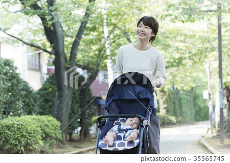 推擠嬰兒推車的中間婦女 推擠嬰兒推車的中間婦女 35565745