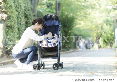Middle woman pushing a stroller Middle woman pushing a stroller 35565767
