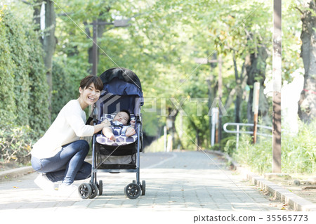 Middle woman pushing a stroller Middle woman pushing a stroller 35565773