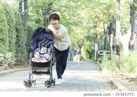 Middle woman pushing a stroller Middle woman pushing a stroller 35565775