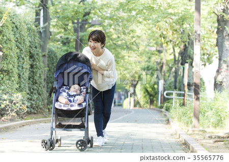 Middle woman pushing a stroller Middle woman pushing a stroller 35565776
