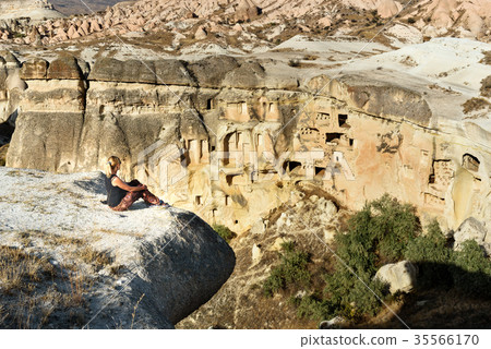 Woman tourist sitting on cliff. Cappadocia. Turkey 35566170