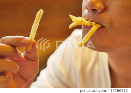 man eating french fries, fried fast food 35566812