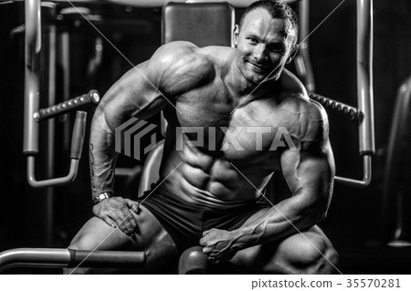 Brutal Caucasian bodybuilder working out in gym 35570281