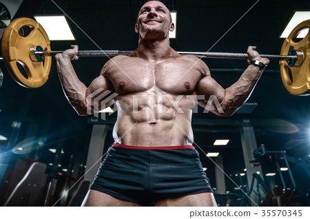 Handsome model young man training legs in gym Handsome model young man training legs in gym 35570345