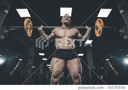 Handsome model young man training legs in gym Handsome model young man training legs in gym 35570350