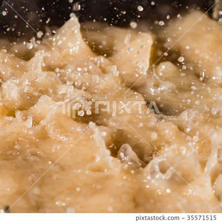 Rain drops fall into a dirty puddle Rain drops fall into a dirty puddle 35571515