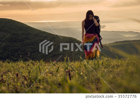 Woman backpacker going to the meadow 35572776