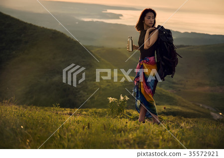 Woman backpacker going to the meadow 35572921