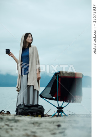 Woman backpacker lakeside tea time 35572937