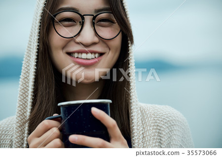 Woman backpacker lakeside tea time 35573066
