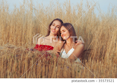 Girlfriends are hugging in the field. Girlfriends are hugging in the field. 35573521