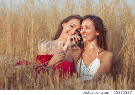 Young women embrace. 35573527