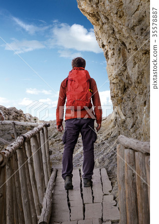 Man hiking with backpack on old wooden bridge 35578887