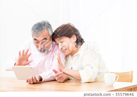Chatting with a senior silver grandson and videophone to enjoy internet calls with family on tablet 35579648