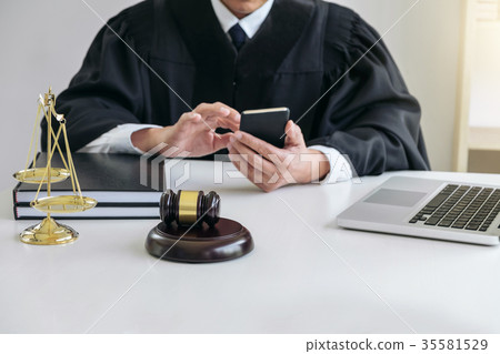 Male lawyer or judge working with smart phone and scales of just 35581529
