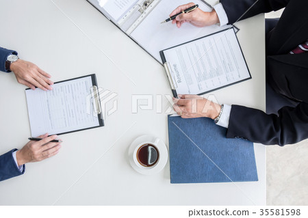 Interviewer or Board reading a resume during a job interview, Em 35581598