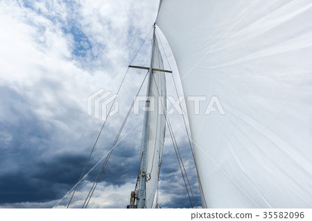 white sail against the cloudy sky background white sail against the cloudy sky background 35582096