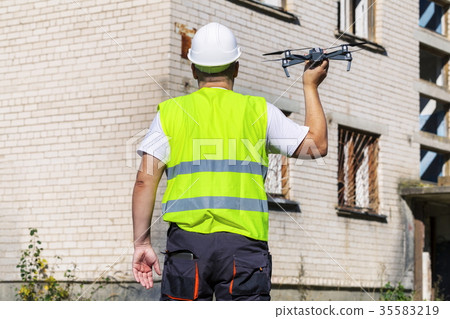 Worker with drone before hand launch 35583219