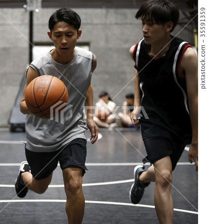 Man playing basketball dribbling 35591359