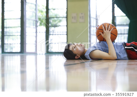 Woman lying on a basketball court Woman lying on a basketball court 35591927