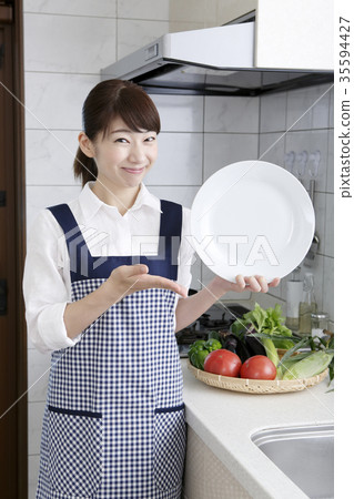 Woman in apron dress with white plate 35594427