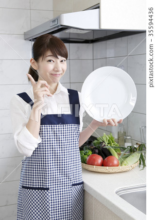 Woman in apron dress with white plate 35594436
