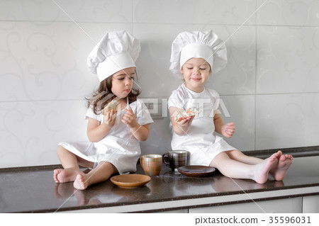 two little baker girls are drinking tea with a 35596031