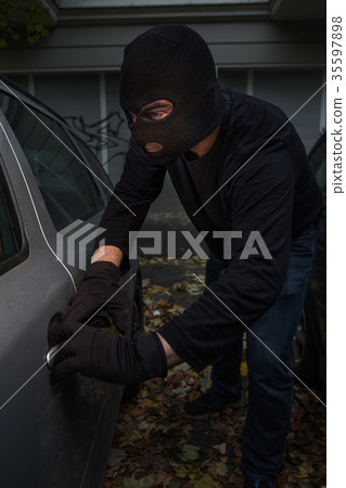 Masked man stealing a car 35597898