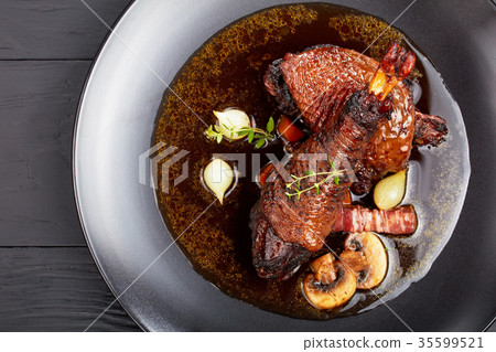 a rooster braised slowly in red wine 35599521