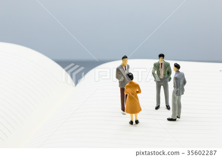 small figures businessmen stand on Blue Notebook 35602287