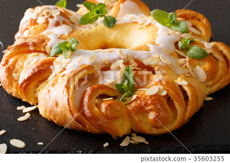 Sweet round brioche with sugar icing and almonds 35603255